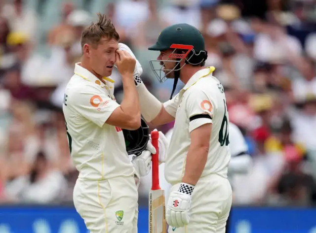 Australia's Travis Head checks Marnus Labuschagne's eye