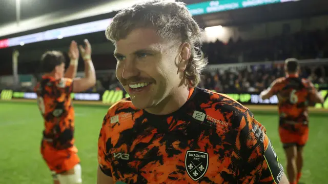 Aaron Wainwright smiles after Dragons' win against Lyon