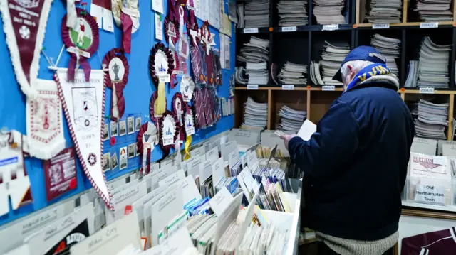 A Wimbledon fan in the Northampton programme shop