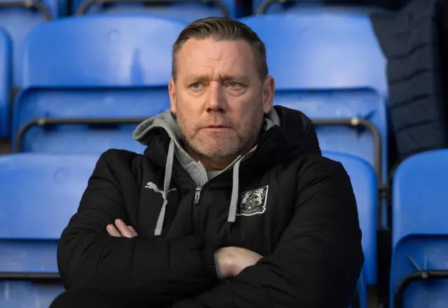 Northampton boss Kevin Nolan sat with arms folded in the dugout during the 2-1 loss at Peterborough