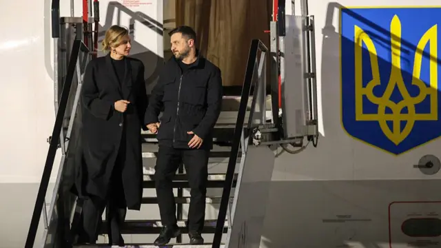 Zelensky and his wife, Zelenska, descend the stairs coming from their official plane, which bears the Ukrainian crest