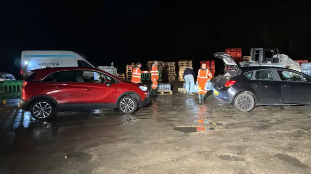 Cars queuing at a water station.