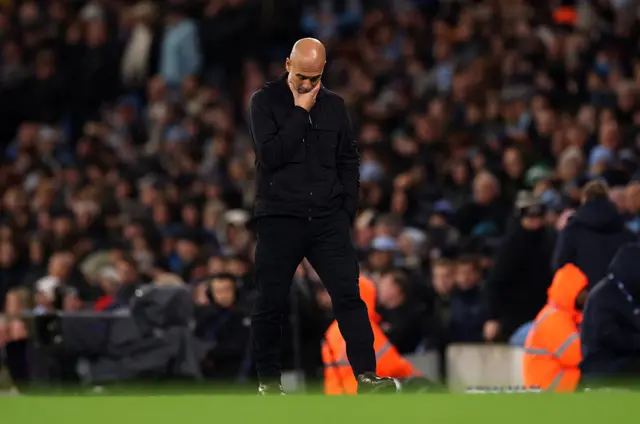 Pep Guardiola walks along touchline