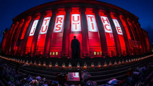 A banner reading Truth and Justice is hung from Liverpool's Saint George's Hall and illuminated in red after a vigil for the 96 victims of the Hillsborough tragedy on April 27, 2016 in Liverpool, England