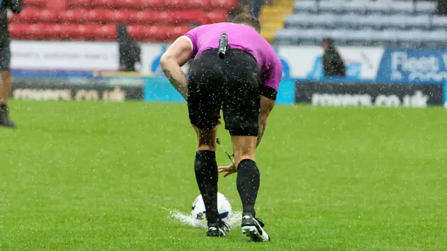 Stephen Martin rolls the ball into a puddle during the initial fixture on 20 September