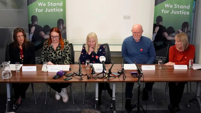 A panel of beareaved families sits in front of microphones