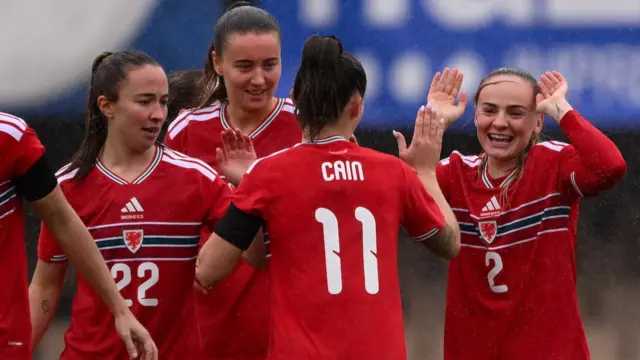 Wales players celebrate with Lily Woodham (R)