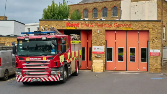 Kent Fire and Rescue Service building with orange doors, red fire truck in front - stock photo