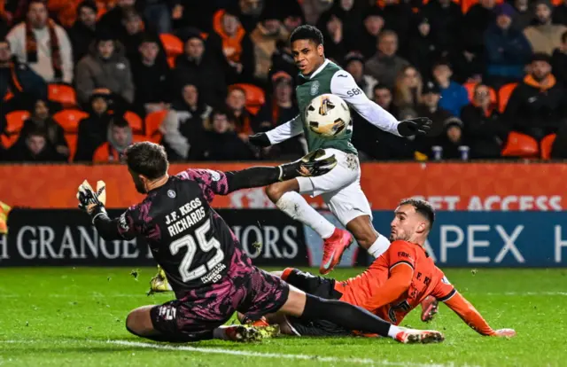 Hibernian's Thibault Klidje (centre) has a shot saved by Dundee United's Dave Richards