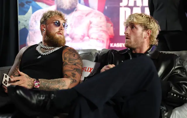 Jake Paul and Logan Paul sit in the changing room prior to the fight