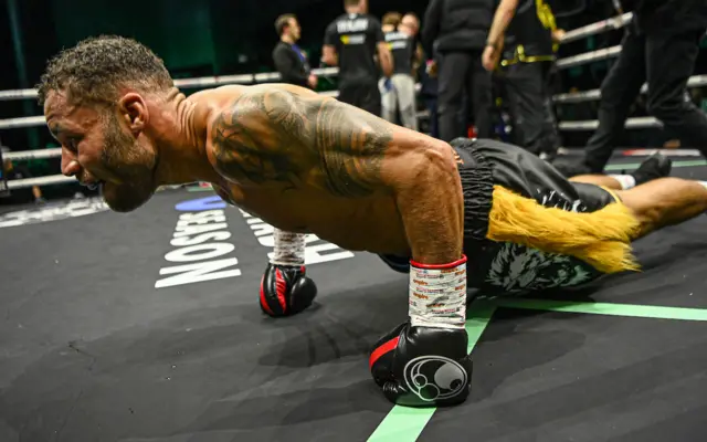Troy Williamson does push ups in the ring celebrating