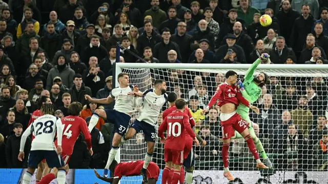 Liverpool's Brazilian goalkeeper #01 Alisson Becker (R) punches the ball away