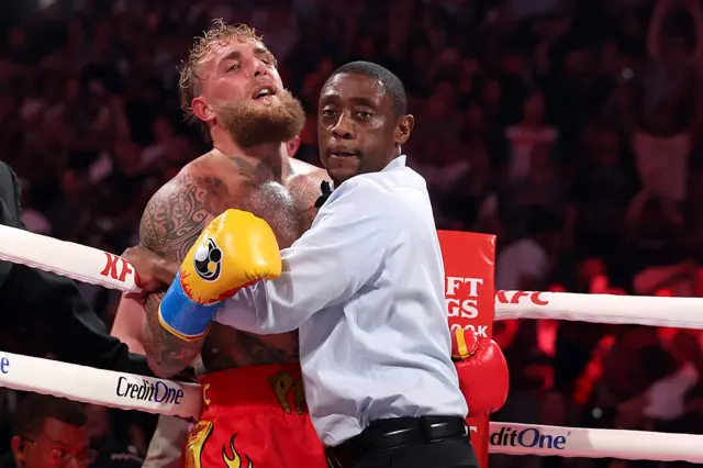 Referee hugs Jake Paul in the ring