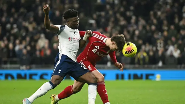 Tottenham Hotspur's Ghanian striker #20 Mohammed Kudus (L) challenges Liverpool's Hungarian defender #06 Milos Kerkez
