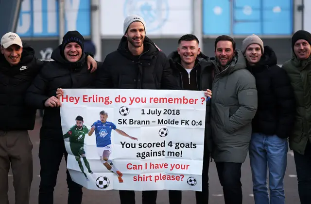 Samuel Sahin-Radlinger, former goalkeeper for SK Brann (3R), is seen holding up a sign reading " Hey Erling, do you remember me? You scored 4 goals against me! Can I have your shirt please?" A reference to Erling Haaland of Manchester City, prior to the Premier League match between Manchester City and West Ham United at Etihad Stadium on December 20, 2025 in Manchester, England.