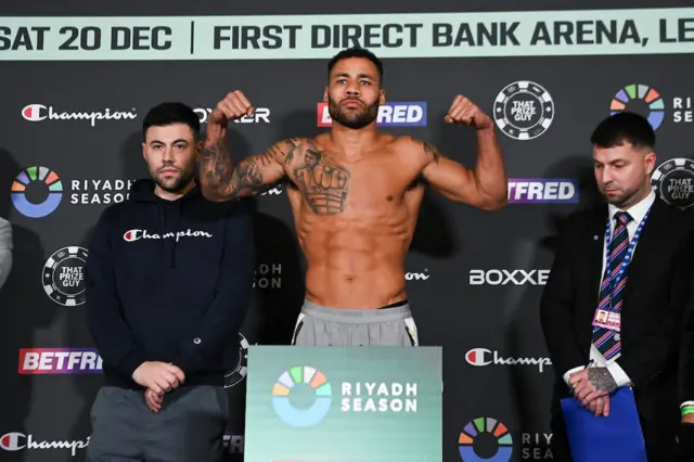 Troy Williamson flexing his biceps on the scales