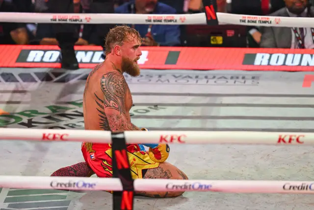 Jake Paul kneels down in a boxing ring