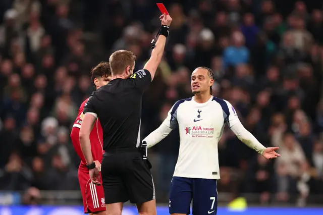 Referee John Brooks shows Xavi Simons of Tottenham Hotspur the red card during the Premier League match between Tottenham Hotspur and Liverpool at Tottenham Hotspur Stadium on December 20, 2025 in London, England.