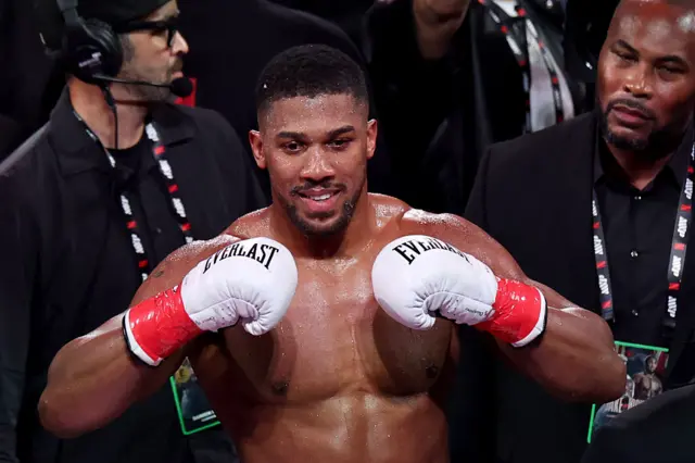 Anthony Joshua holds up his gloves