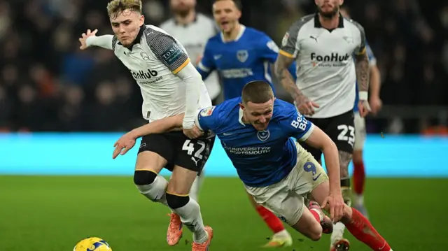 Portsmouth's Colby Bishop takes a tumble under pressure from Derby's Bobby Clark