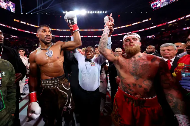 Anthony Joshua and Jake Paul have their arms raised