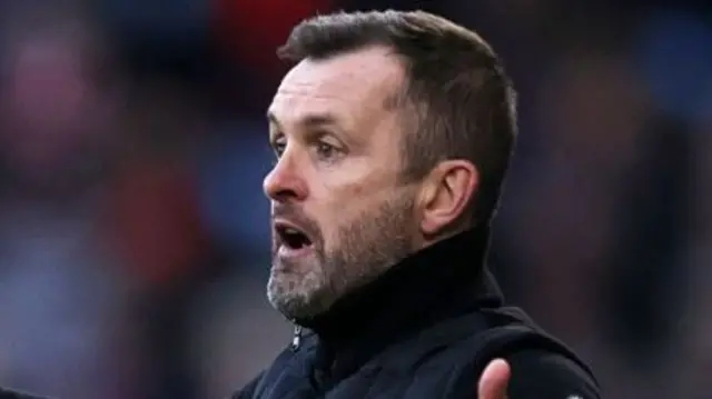 Charlton boss Nathan Jones with his arms out wide on the touchline