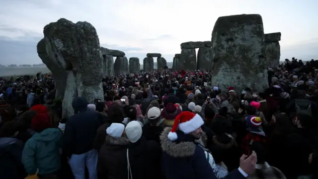 Revellers attend winter solstice celebrations during sunrise at Stonehenge