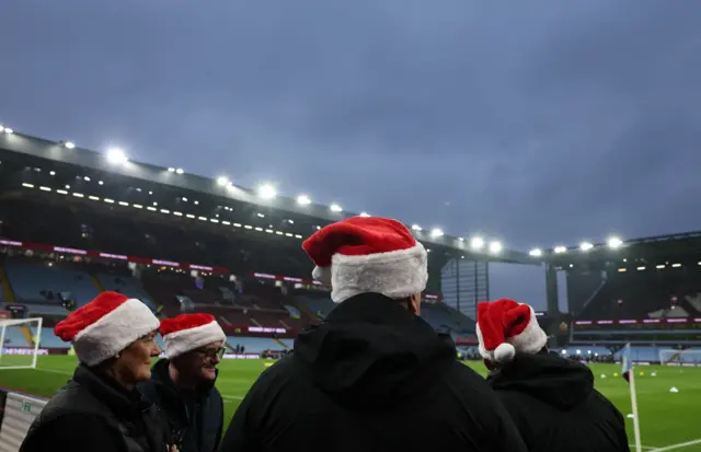 Fans wear Christmas hats inside the stadium before the match