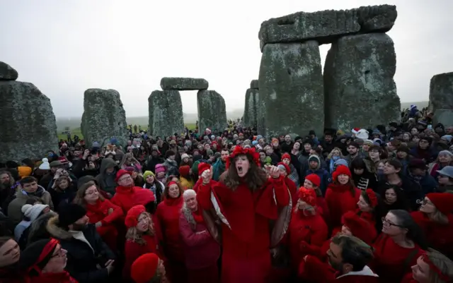Revellers attend winter solstice celebrations during sunrise at Stonehenge stone circle