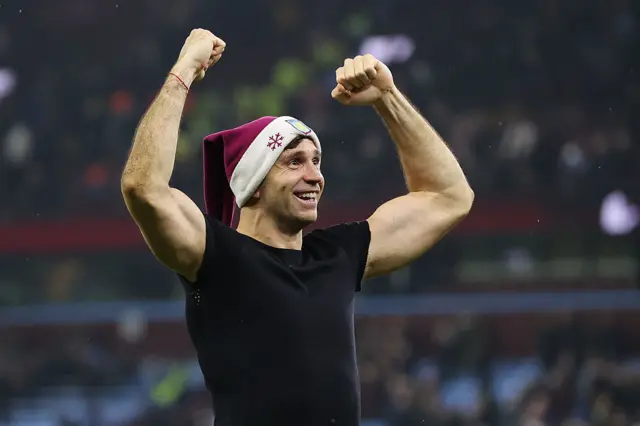 Emiliano Martinez of Aston Villa celebrates while wearing an Aston Villa-themed Santa hat