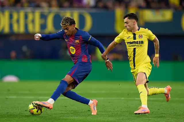 Lamine Yamal of FC Barcelona competes for the ball with Alberto Moleiro of Villarreal CF during the LaLiga EA Sports match between Villarreal CF and FC Barcelona at Estadio de la Ceramica on December 21, 2025 in Villarreal, Spain.
