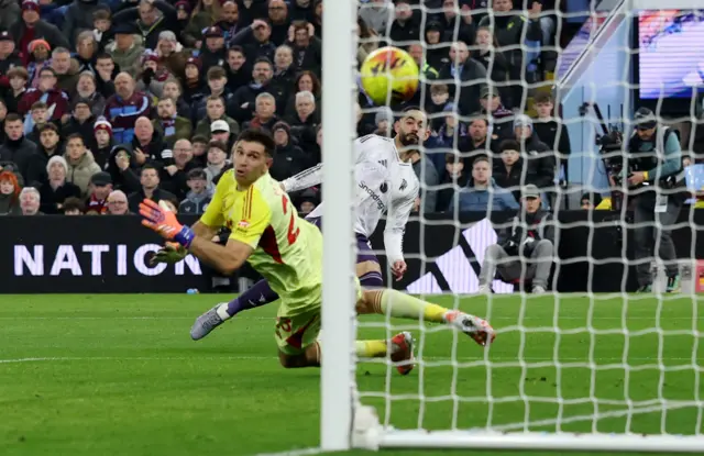 Manchester United's Matheus Cunha scores their first goal past Aston Villa's Emiliano Martinez