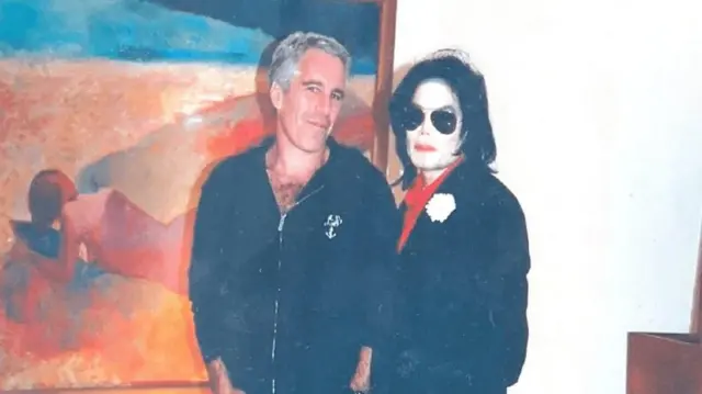 Jeffrey Epstein sands next to Michael Jackson in front of a red painting of a woman lying down