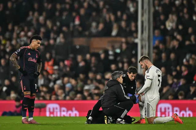 Nottingham Forest's Brazilian striker #19 Igor Jesus (L) watches as Fulham's Danish defender #05 Joachim Andersen receives medical treatment