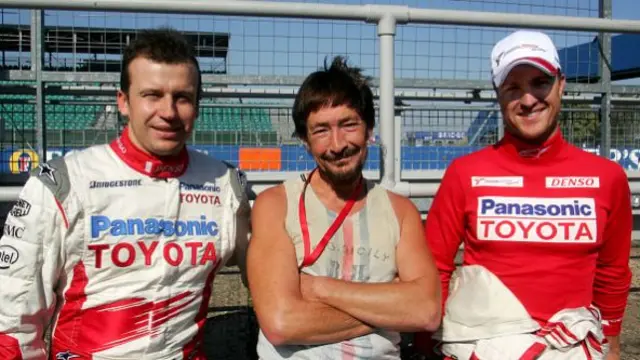 Chris Rea stands between Olivier Panis and Ralf Schumacher, who are both wearing Toyota uniforms