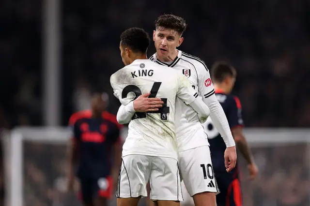 Tom Cairney and Joshua King of Fulham embrace after the team's victory in the Premier League match between Fulham and Nottingham Forest at Craven Cottage on December 22, 2025 in London, England.