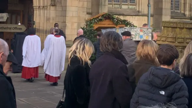 Coffin being carried into cathedral