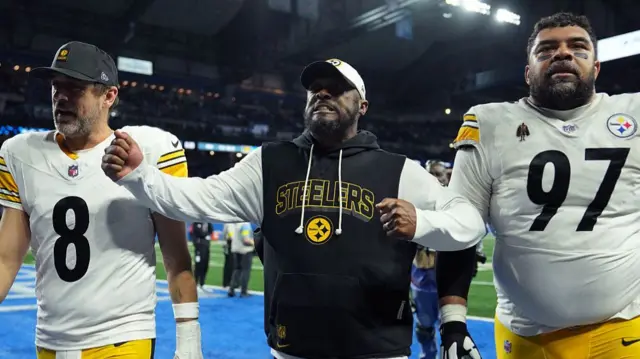 Head coach Mike Tomlin walks off the field with Aaron Rodgers and Cameron Heyward of the Pittsburgh Steelers after beating the Detroit Lions