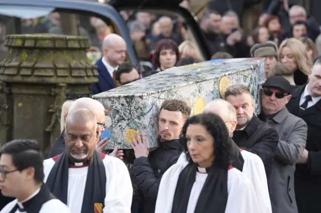 Coffin being carried into cathedral