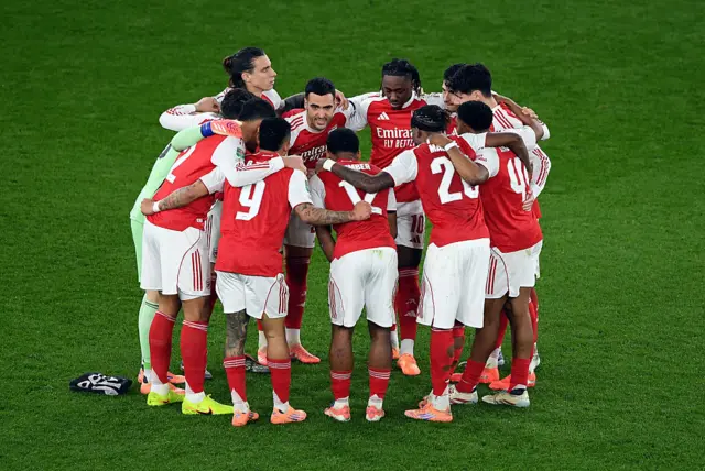 Arsenal players gather in a huddle before the start of the second half