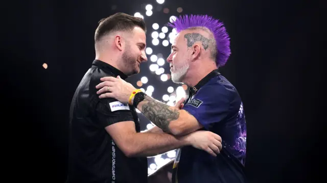 Arno Merk and Peter Wright embrace