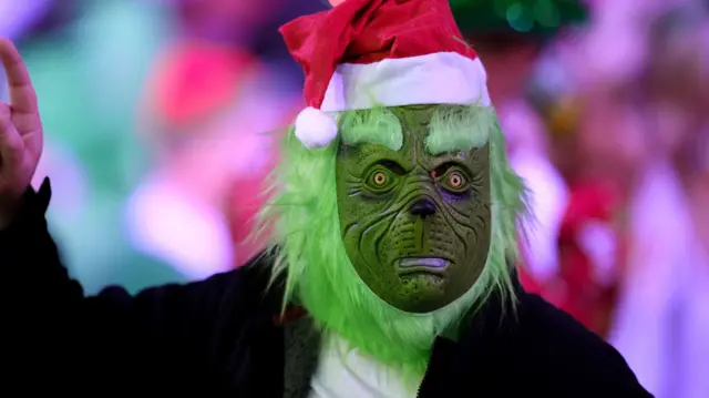 Darts fan in a Grinch mask
