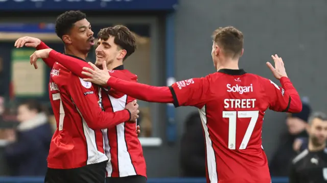 Lincoln celebrate reeco Hackett's goal at Stockport