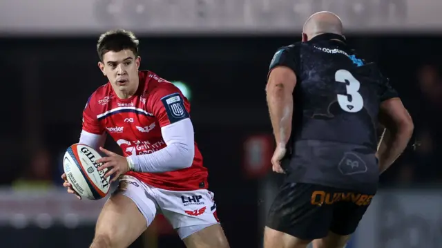 Joe Hawkins of Scarlets is challenged by Rhys Henry of Ospreys