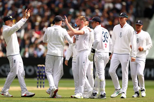 Gus Atkinson of England celebrates with teammates the wicket of Travis Head