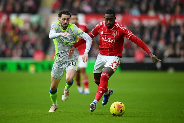 Callum Hudson-Odoi of Nottingham Forest is challenged by Bernardo Silva of Manchester City during the Premier League match between Nottingham Forest and Manchester City at the City Ground on December 27, 2025 in Nottingham, England.