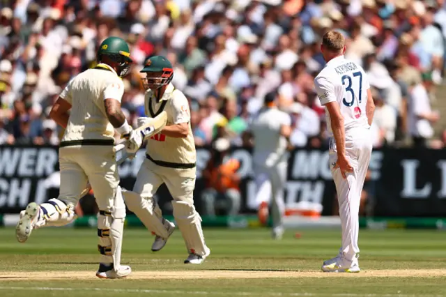 Gus Atkinson of England holds his left leg after a bowling
