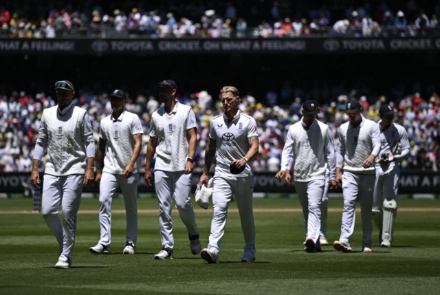 Ben Stokes of England (C) leads England off the field