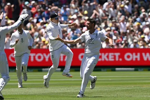 England bowler Josh Tongue (R) is congratulated by teammates after dismissing Australia's Usman Khawaja
