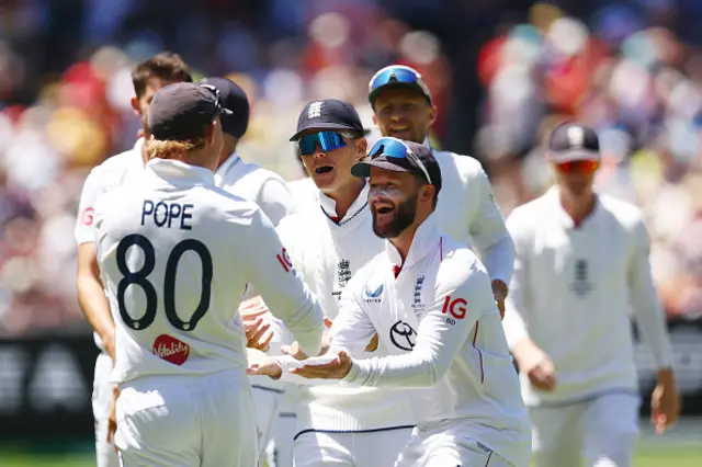 Ollie Pope of England (L) celebrates with his teammates after catching out Usman Khawaja